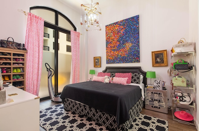 bedroom with a notable chandelier and hardwood / wood-style flooring