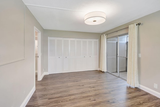 unfurnished bedroom with hardwood / wood-style flooring, a textured ceiling, and a closet