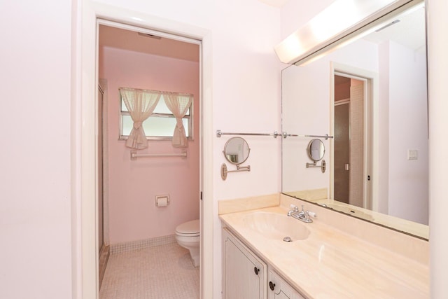 bathroom featuring tile patterned flooring, vanity, and toilet