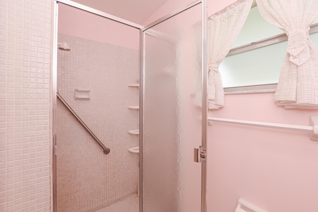 bathroom with a shower with door