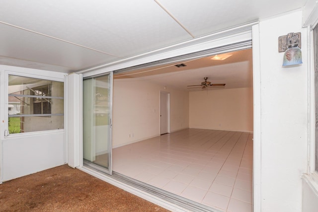 unfurnished sunroom with ceiling fan