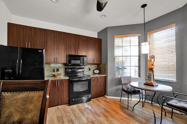 kitchen featuring black appliances, light wood-type flooring, backsplash, ceiling fan, and pendant lighting