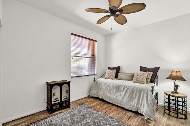 bedroom with wood finished floors, baseboards, and ceiling fan