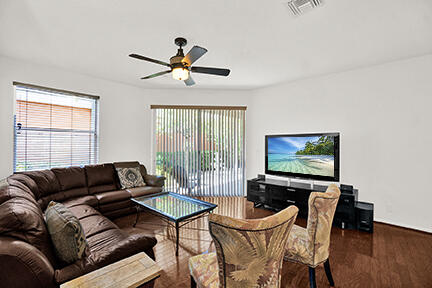 living area featuring ceiling fan, wood finished floors, and baseboards