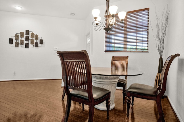 dining area with wood-type flooring, a chandelier, and baseboards