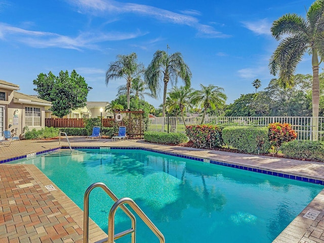 community pool with fence and a patio area