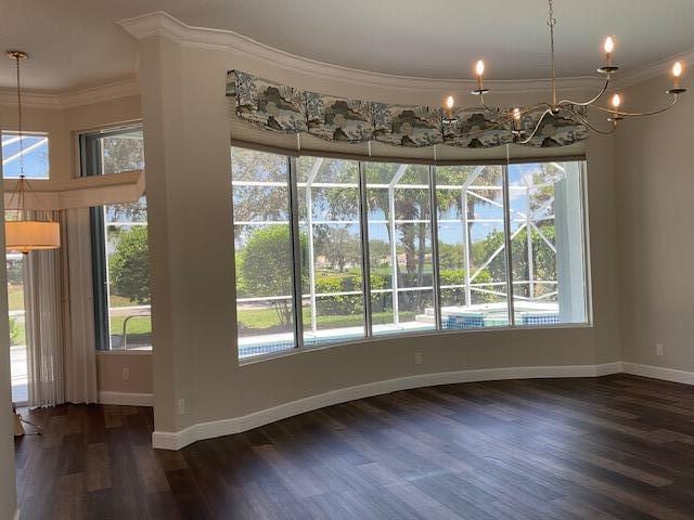 unfurnished dining area featuring ornamental molding, a wealth of natural light, and wood finished floors