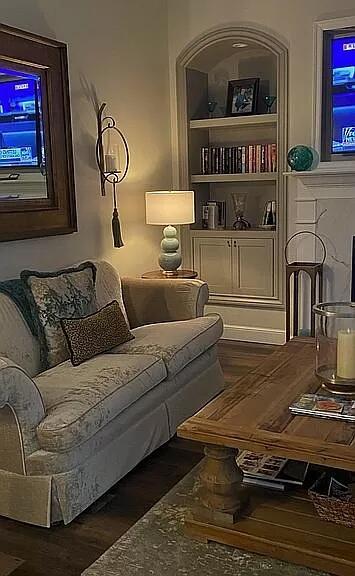 living room with built in features and wood finished floors