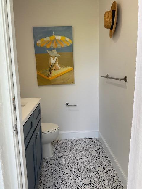 bathroom featuring baseboards, vanity, toilet, and tile patterned floors