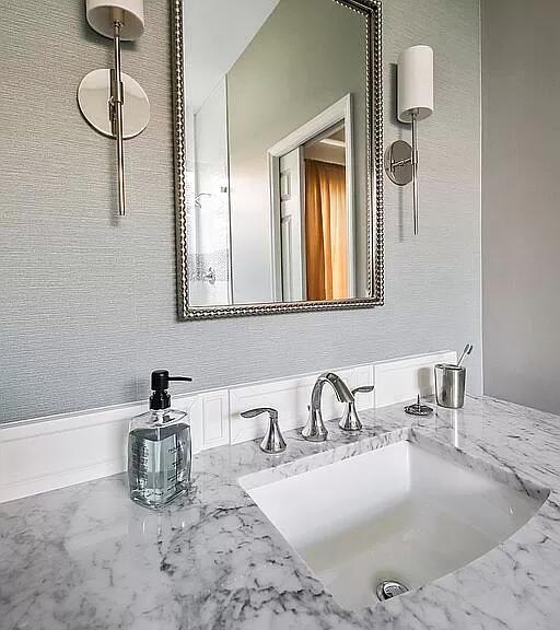 bathroom featuring marble finish floor and a sink