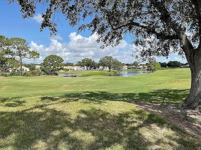 surrounding community with view of golf course, a water view, and a lawn