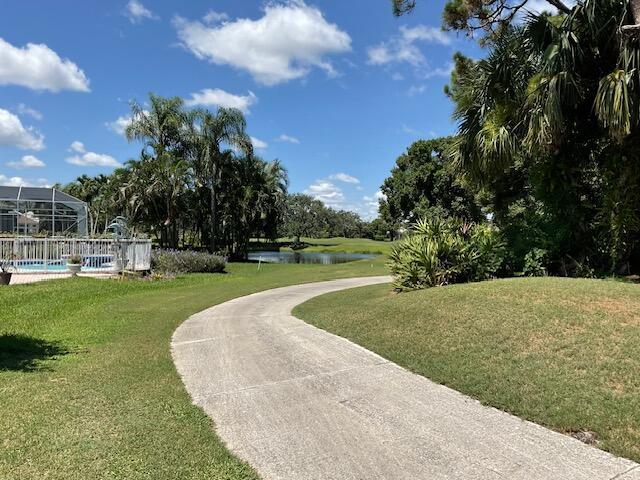 surrounding community with a water view, a yard, and a swimming pool