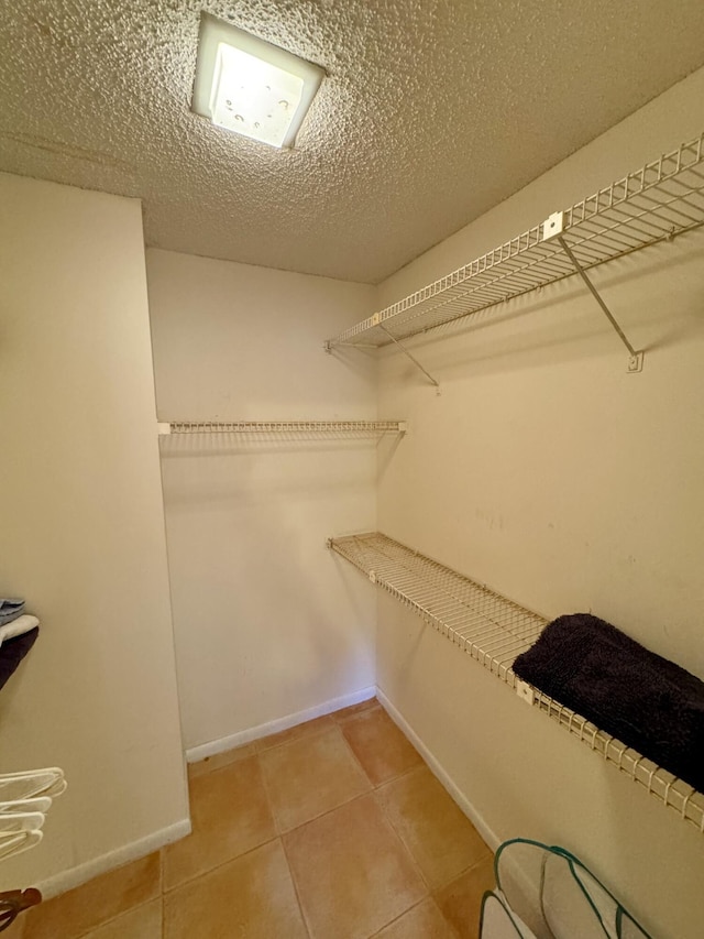 walk in closet with tile patterned floors