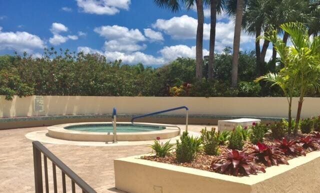 view of swimming pool with an in ground hot tub