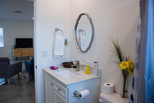 bathroom with vanity, toilet, and tile patterned floors