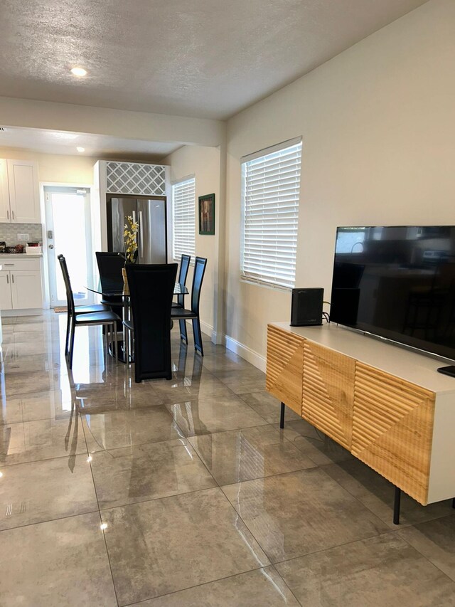 tiled dining room featuring a textured ceiling