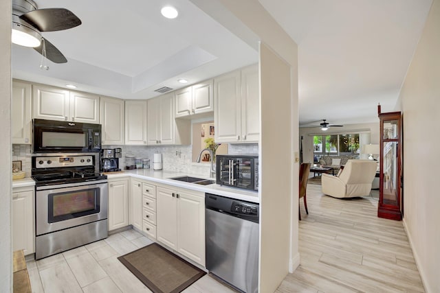 kitchen with sink, appliances with stainless steel finishes, ceiling fan, and white cabinets