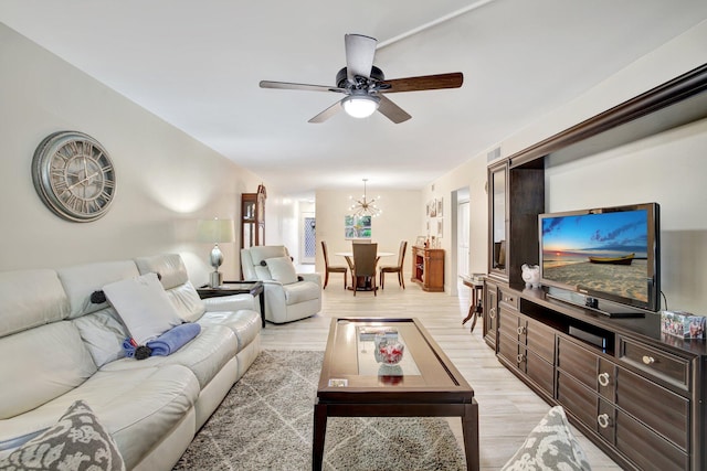 living room featuring ceiling fan with notable chandelier and hardwood / wood-style flooring