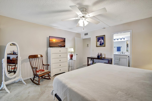 tiled bedroom with sink, ensuite bathroom, a textured ceiling, and ceiling fan