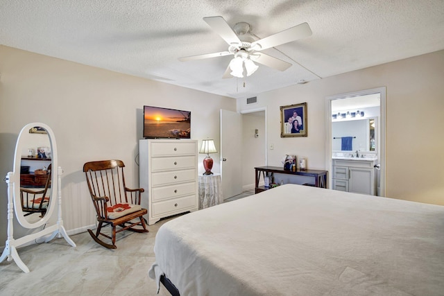 2004 Granada Dr Unit L2, Coconut Creek, FL 33066 - bedroom featuring a textured ceiling, a sink, ensuite bathroom, baseboards, and a ceiling fan