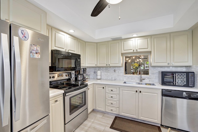 2004 Granada Dr Unit L2, Coconut Creek, FL 33066 - kitchen featuring appliances with stainless steel finishes, a ceiling fan, a sink, a tray ceiling, and recessed lighting