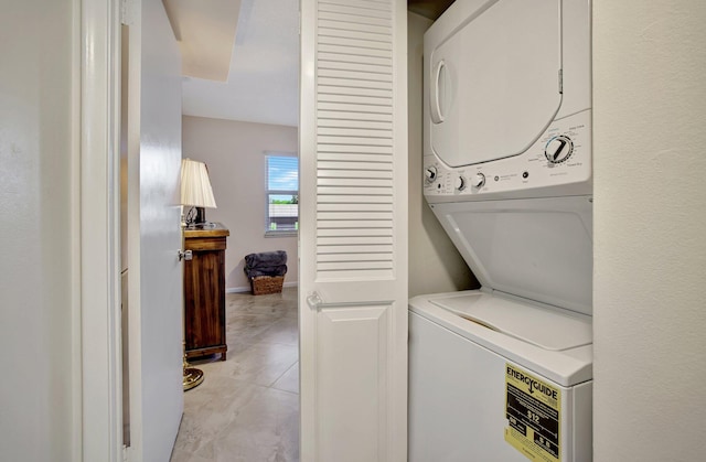 clothes washing area with stacked washing maching and dryer and light tile patterned floors