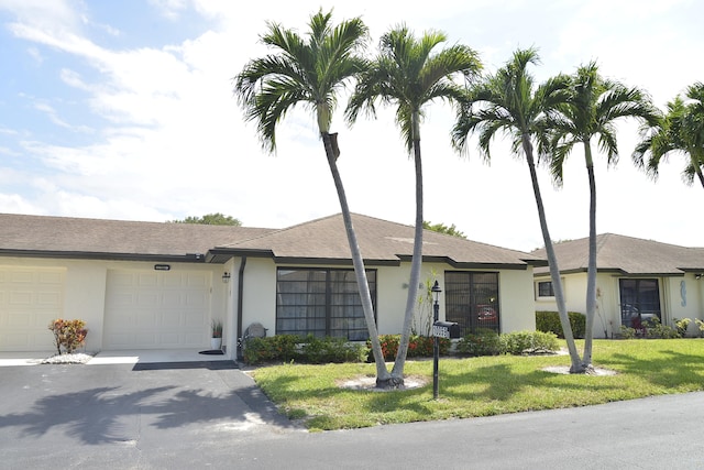 single story home with a garage and a front yard