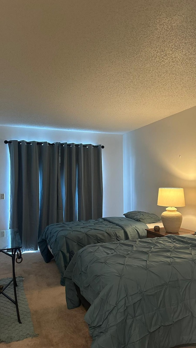 bedroom featuring carpet and a textured ceiling