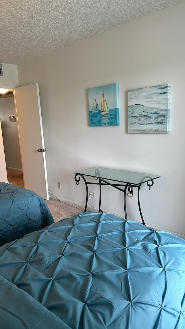 bedroom featuring carpet flooring and a textured ceiling