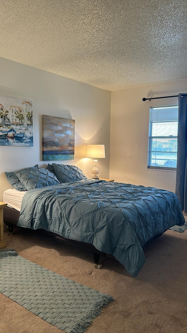 bedroom featuring a textured ceiling and carpet flooring