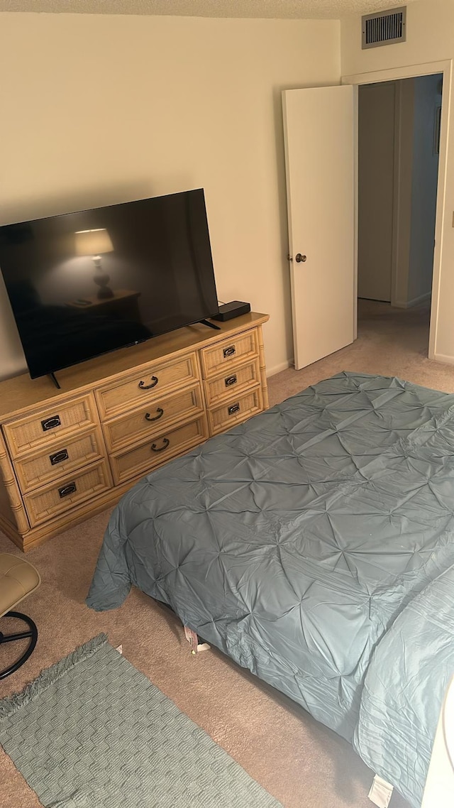 bedroom featuring carpet and a textured ceiling