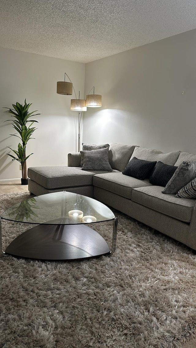 carpeted living room featuring a textured ceiling