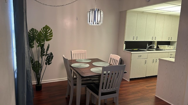 dining room featuring a notable chandelier, dark hardwood / wood-style flooring, and sink