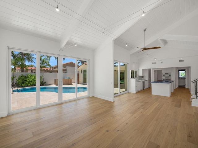 unfurnished living room featuring ceiling fan, wooden ceiling, beamed ceiling, and light hardwood / wood-style flooring