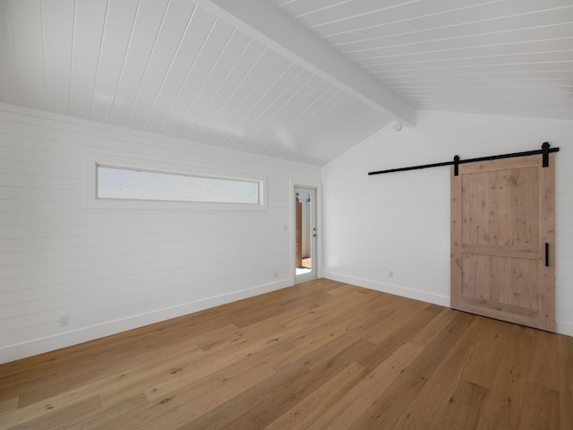 bonus room with a barn door, beamed ceiling, and hardwood / wood-style flooring