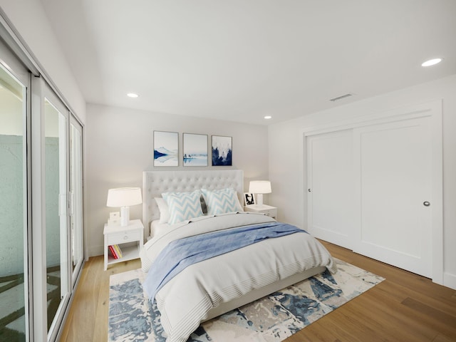 bedroom with access to exterior and hardwood / wood-style floors