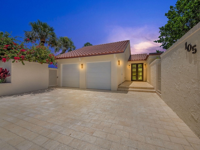 view of front of house with a garage and french doors