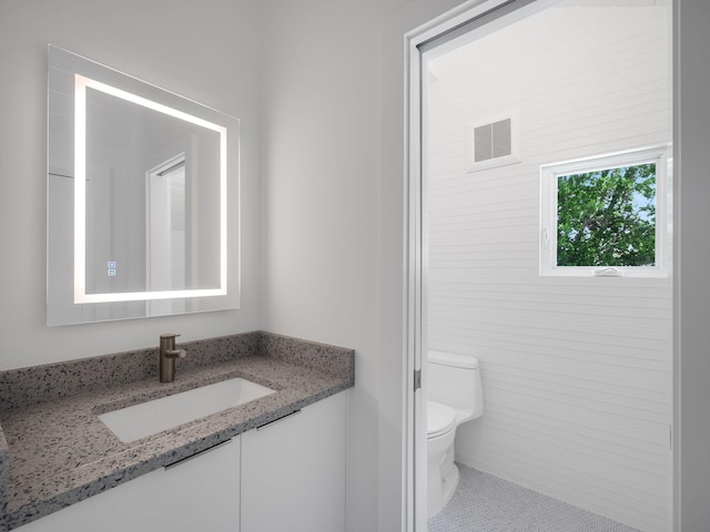 bathroom featuring toilet, tile patterned floors, and vanity