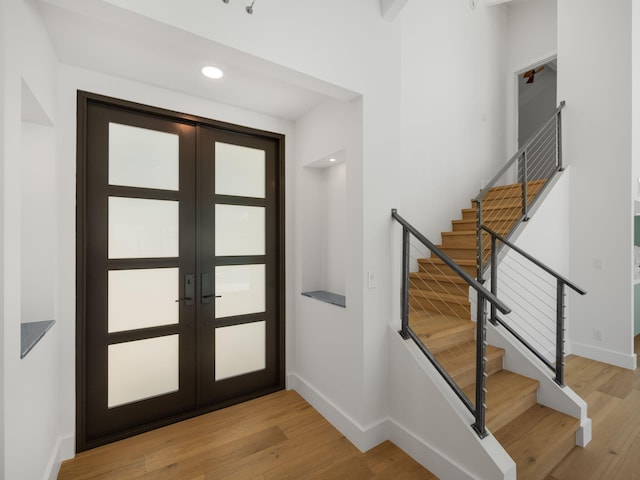 foyer with light hardwood / wood-style flooring and french doors