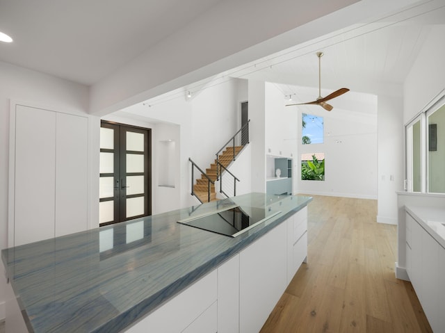 kitchen with white cabinets, french doors, light wood-type flooring, ceiling fan, and black electric cooktop