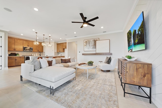 tiled living room with ceiling fan, ornamental molding, and sink