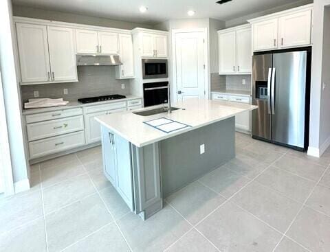 kitchen featuring a kitchen island with sink, white cabinets, and black appliances