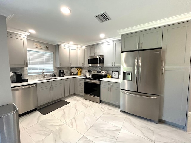 kitchen with backsplash, stainless steel appliances, crown molding, and sink