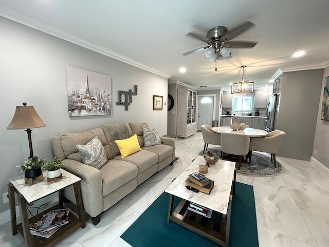 living room with ceiling fan with notable chandelier and ornamental molding