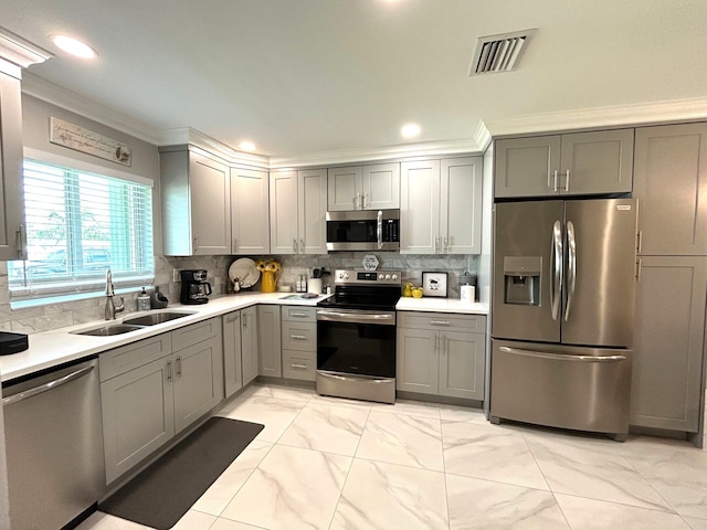 kitchen featuring gray cabinetry, stainless steel appliances, sink, and ornamental molding