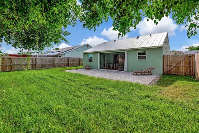 rear view of house with a yard and a patio