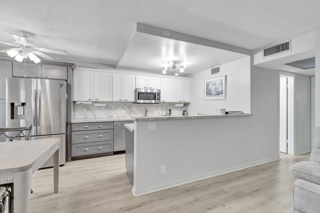 kitchen featuring gray cabinets, white cabinets, kitchen peninsula, and stainless steel appliances