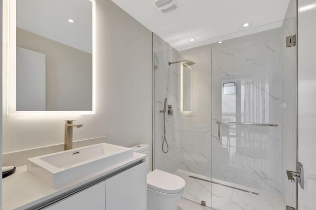 bathroom with a shower with door, toilet, and vanity