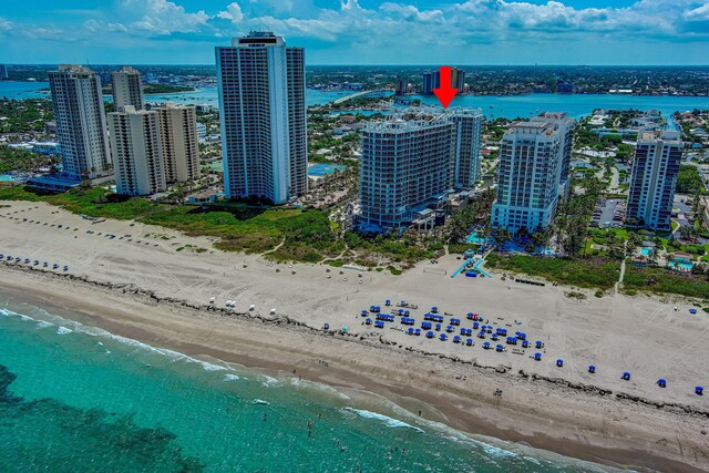 birds eye view of property with a water view and a beach view