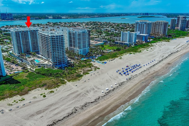 drone / aerial view with a water view and a beach view